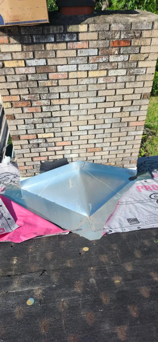 Hand formed galvanized chimney pan sitting on Owens Corning synthetic underlayment on a stripped roof deck