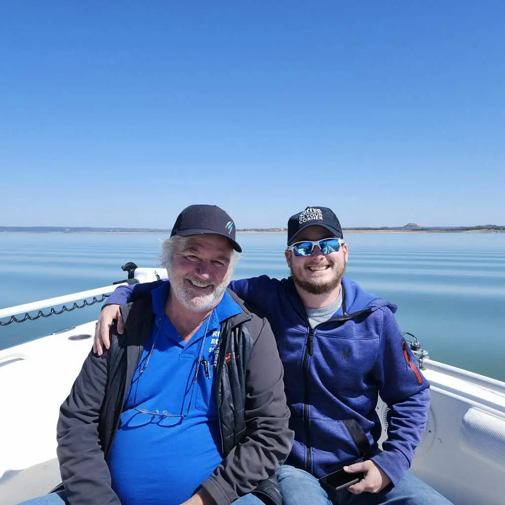 Frank and Jake Ruddy seated together on a boat on open water