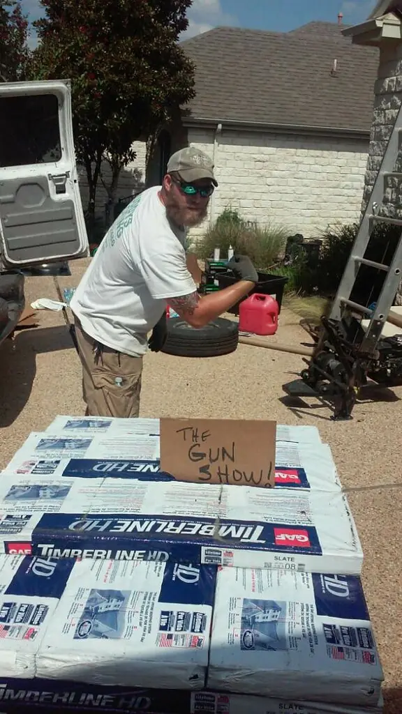 Stacked GAF Timberline HD shingle bundles on a driveway before a roof install
