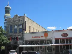 Historic limestone storefronts on the downtown Georgetown square with an onion dome tower on the corner