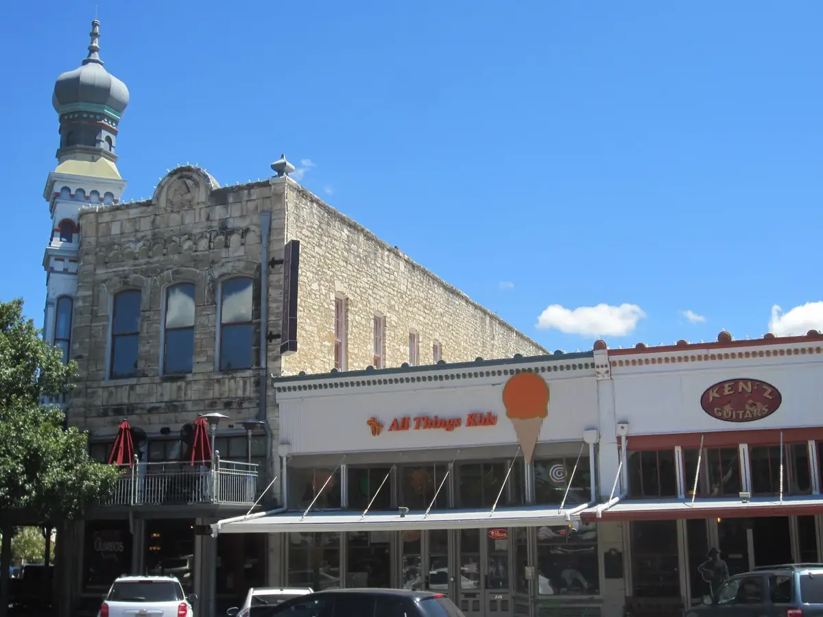 Historic limestone storefronts on the downtown Georgetown square with an onion dome tower on the corner