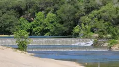 Water spilling over the low dam on the San Gabriel River at Blue Hole Park in Georgetown