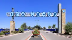 The Co-op District gateway sign over the entry road in Hutto under a clear blue sky