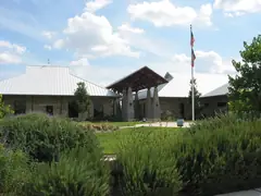 The stone front of the Leander Public Library with its metal roof and flagpole