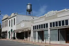 Limestone storefronts on Main Street in downtown Round Rock with the old water tower behind them